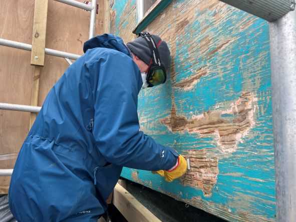 A conservator strips paint from Damoy