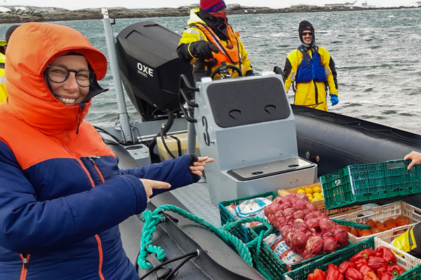 Jo in front of a zodiac full of fresh veggies