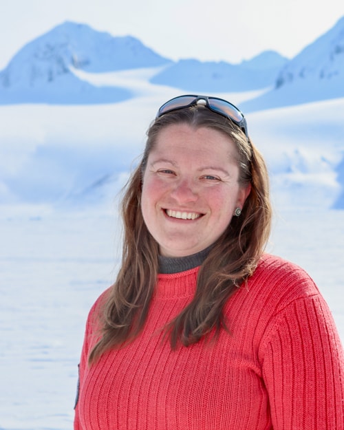Profile shot of Katie in a red jumper on ice
