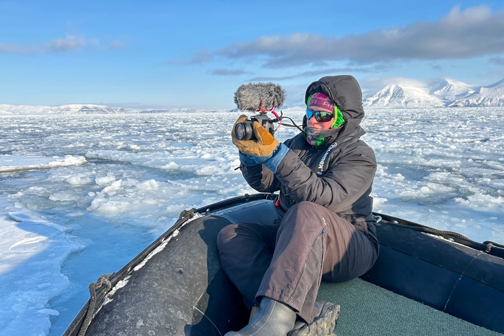 Katie with a camera on a zodiac boat in Svalbard