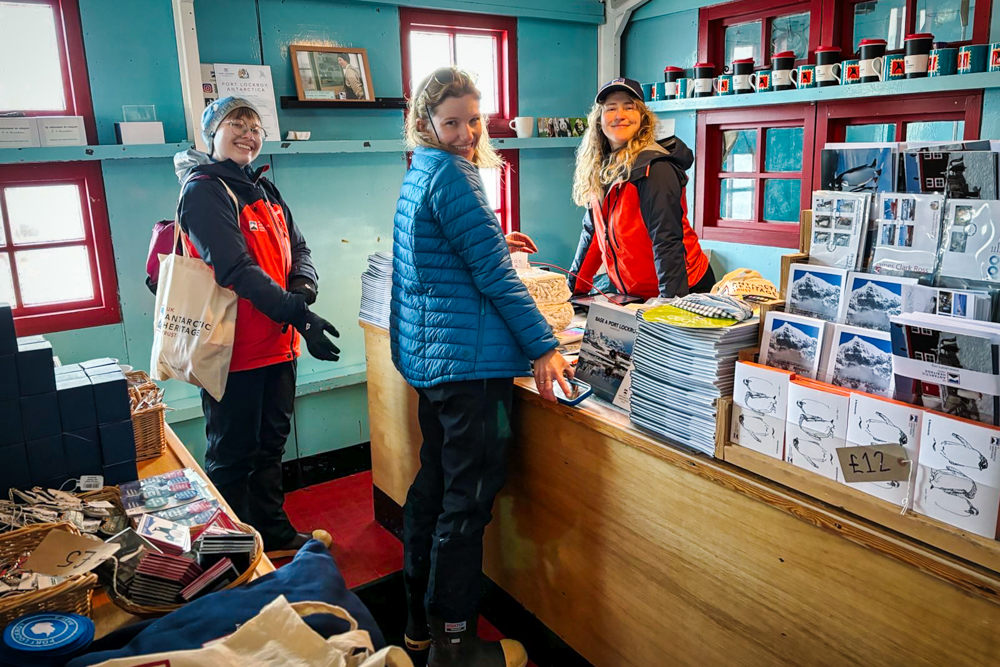 Three team members beside a till and shelves of stock