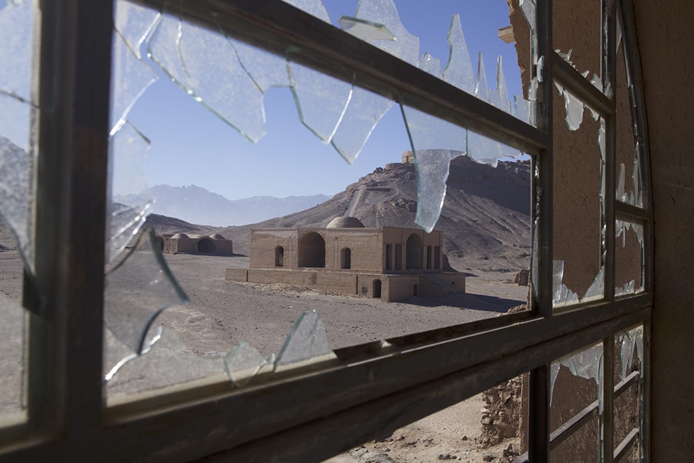 looking through a broken window at ruins