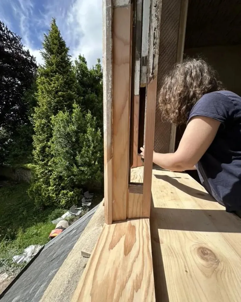 Conservation carpenter Kate Walford working on a wooden window frame